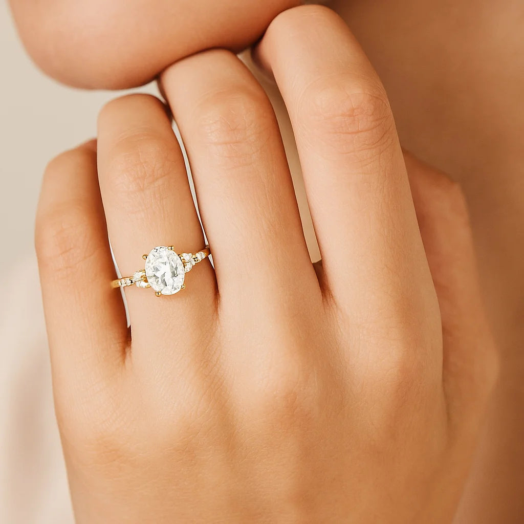 Gold Plated ring with a diamond on a hand against a beige background