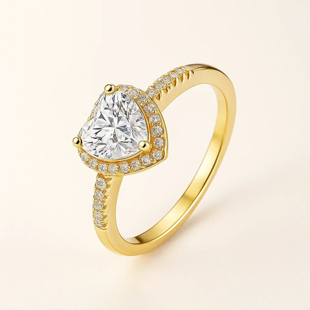 Gold Plated ring with a large central diamond and smaller diamonds on the band against a light beige background