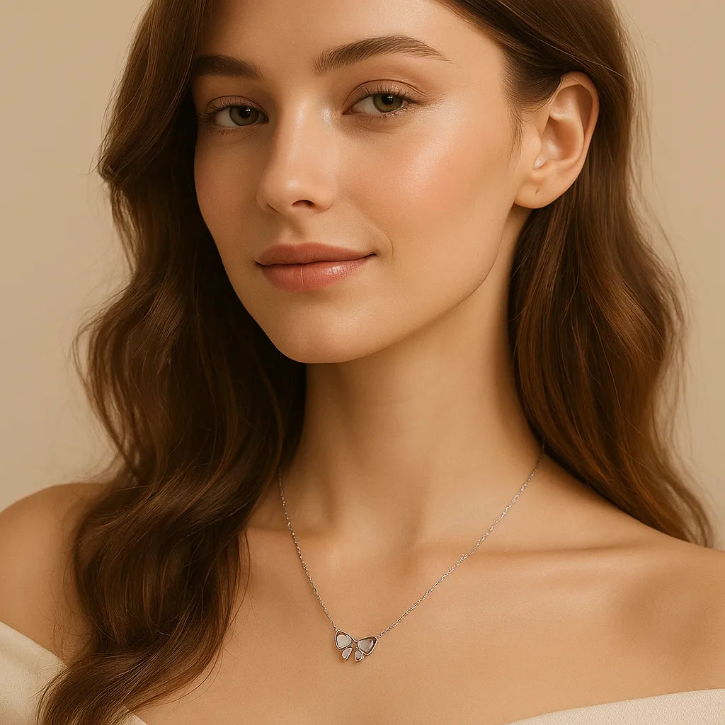 Woman wearing a delicate necklace with a BOW pendant against a neutral background