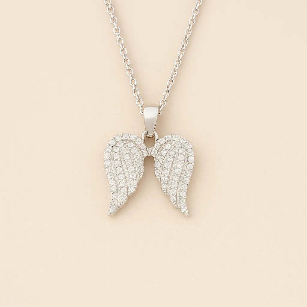Silver angel wing pendant necklace on a beige background