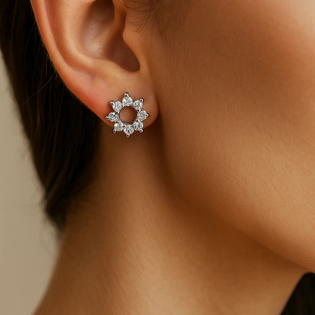 Close-up of an ear wearing a silver earring with a beige background