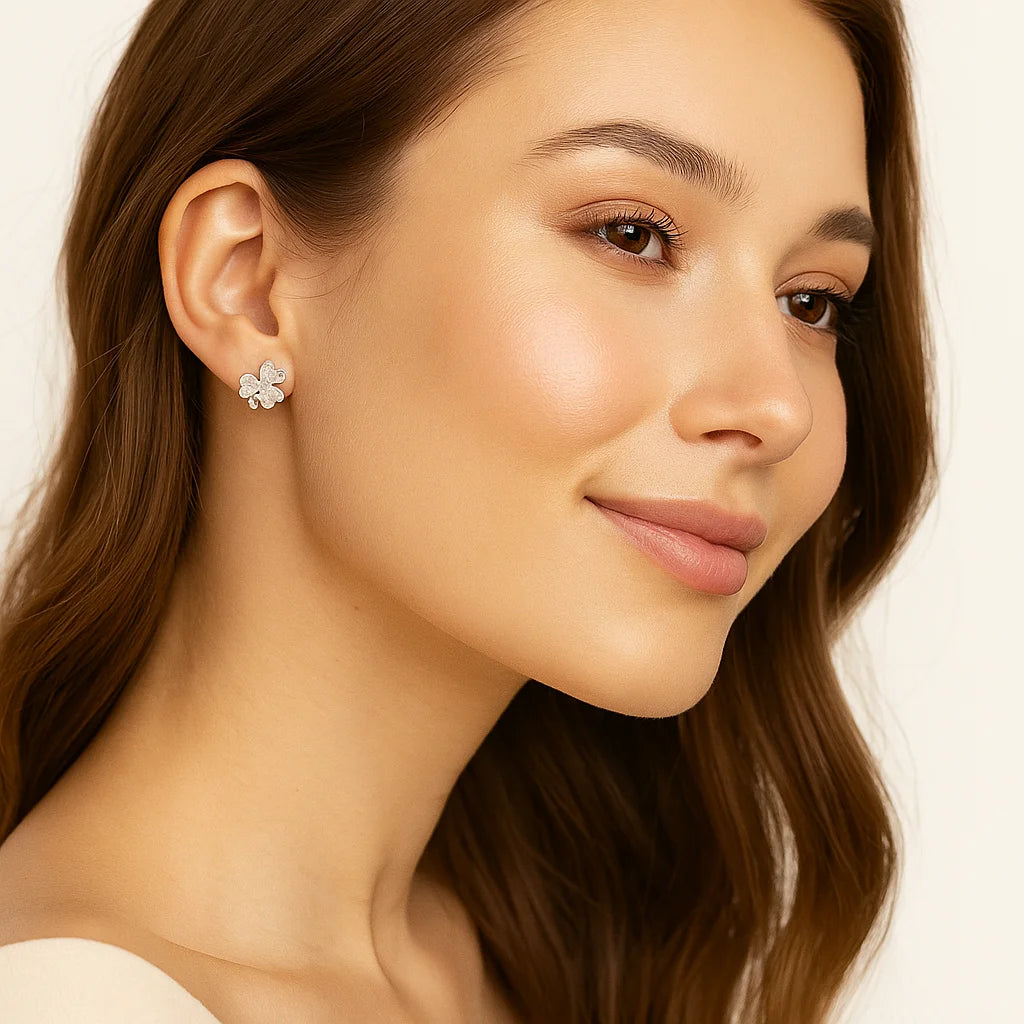 Close-up of a woman wearing a silver earring with a beige background