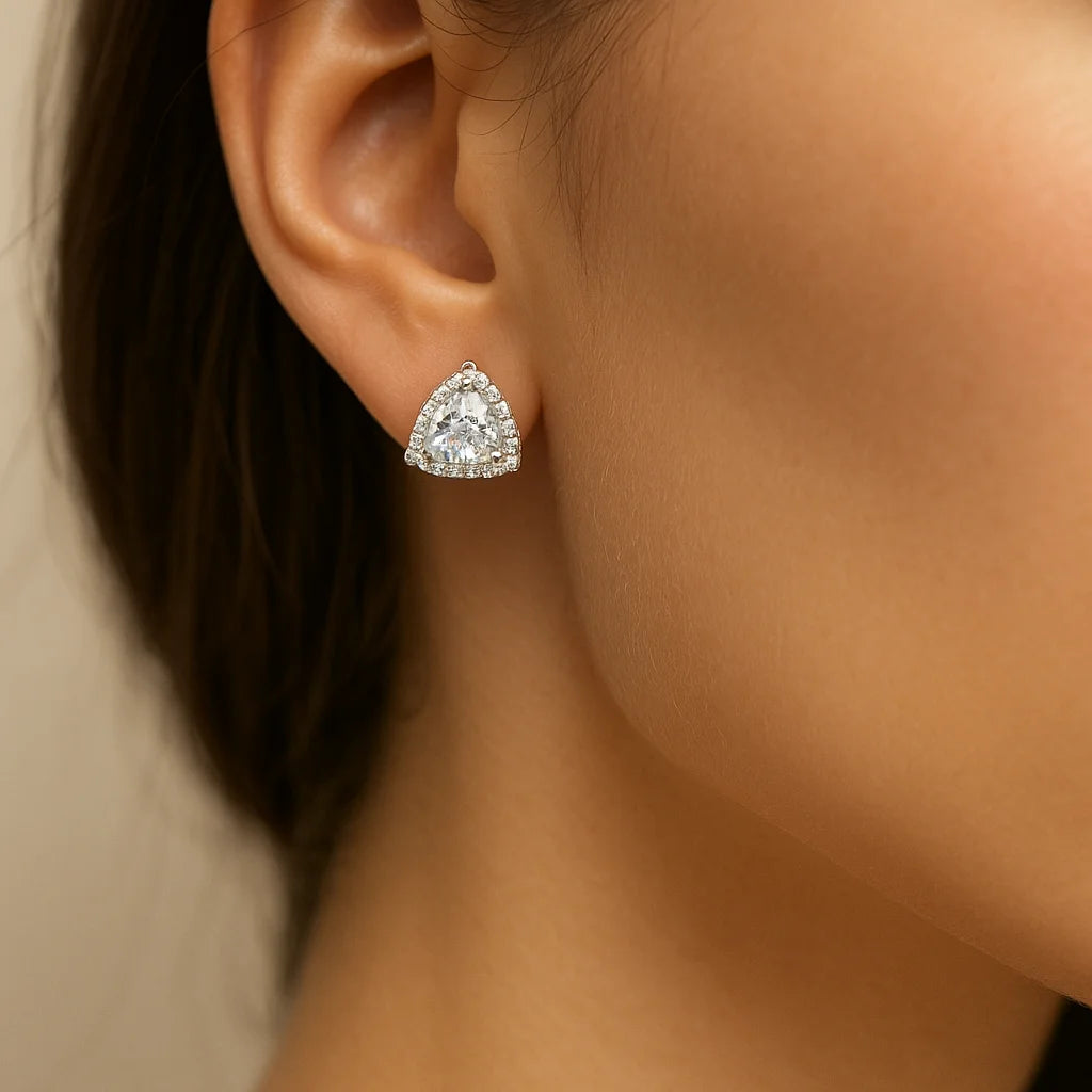 Trillion cut diamond earring on a model's ear against a neutral background