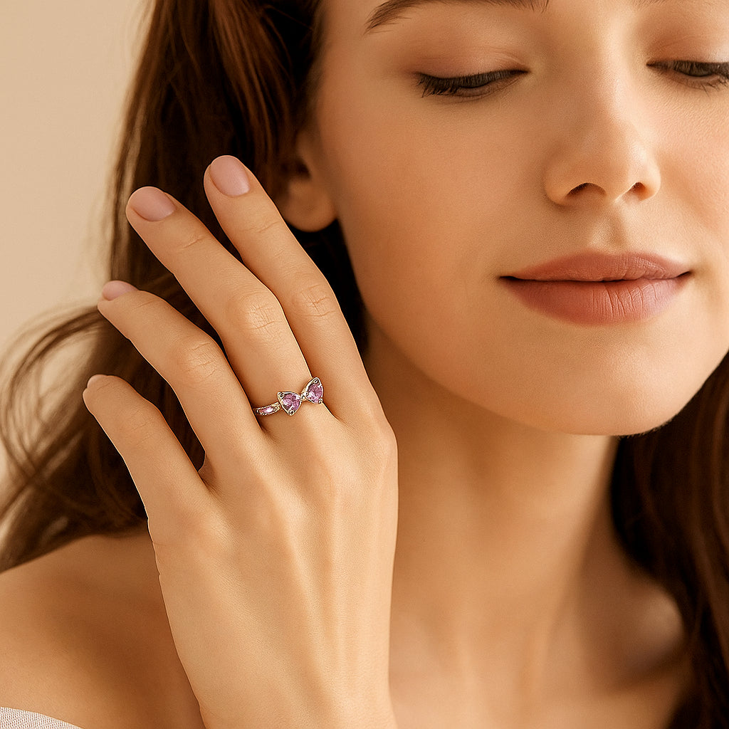 Woman wearing a ring with a purple gemstone on a neutral background