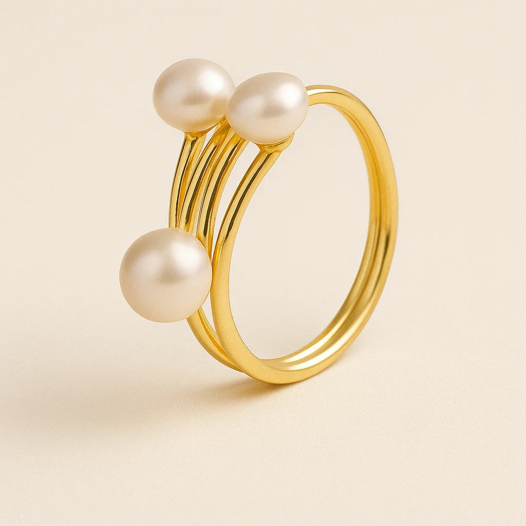 Golden ring with three pearls on a beige background
