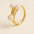 Golden ring with three pearls on a beige background