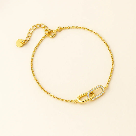 Gold bracelet with a lock charm on a beige background