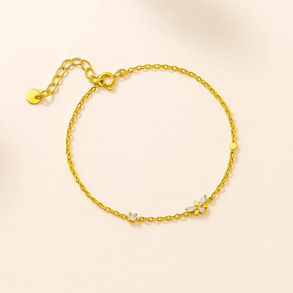 Gold bracelet with small stones on a beige background