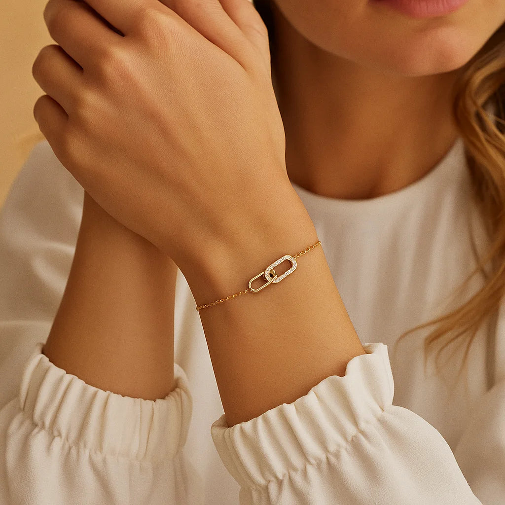 Gold bracelet on a wrist with a neutral background