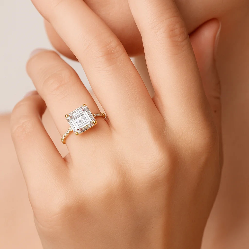 Gold ring with a large diamond on a hand against a neutral background