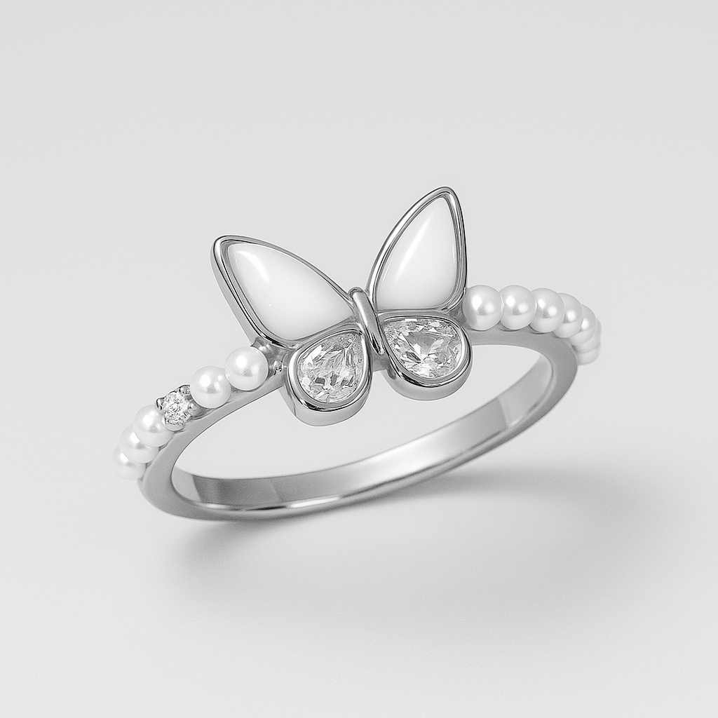 Silver butterfly ring with pearls and gemstones on a light gray background