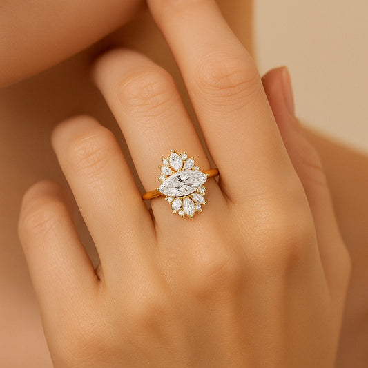 Gold plated ring with a diamond on a hand against a beige background