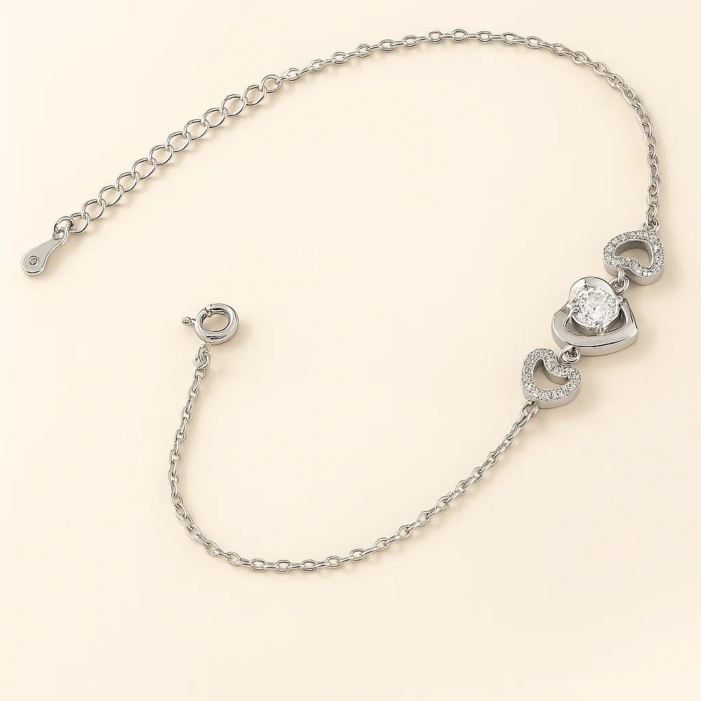 Silver bracelet with heart-shaped charms on a beige background