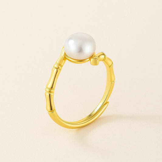 Gold ring with a pearl on a beige background