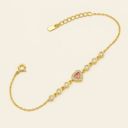 A gold-plated 925 sterling silver bracelet with a central pink heart charm and a line of sparkling cubic zirconia stones.