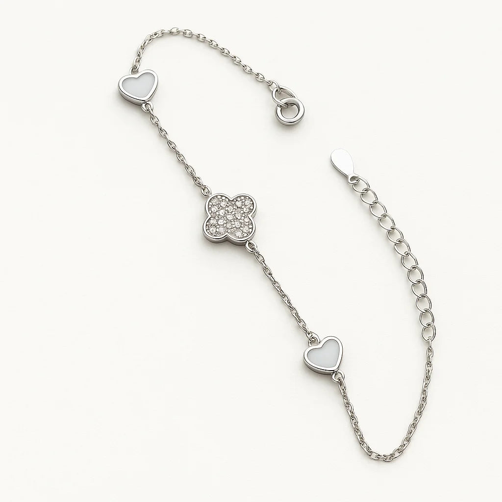 A beautiful gold-plated sterling silver bracelet featuring a central pavé clover charm flanked by two heart charms.
