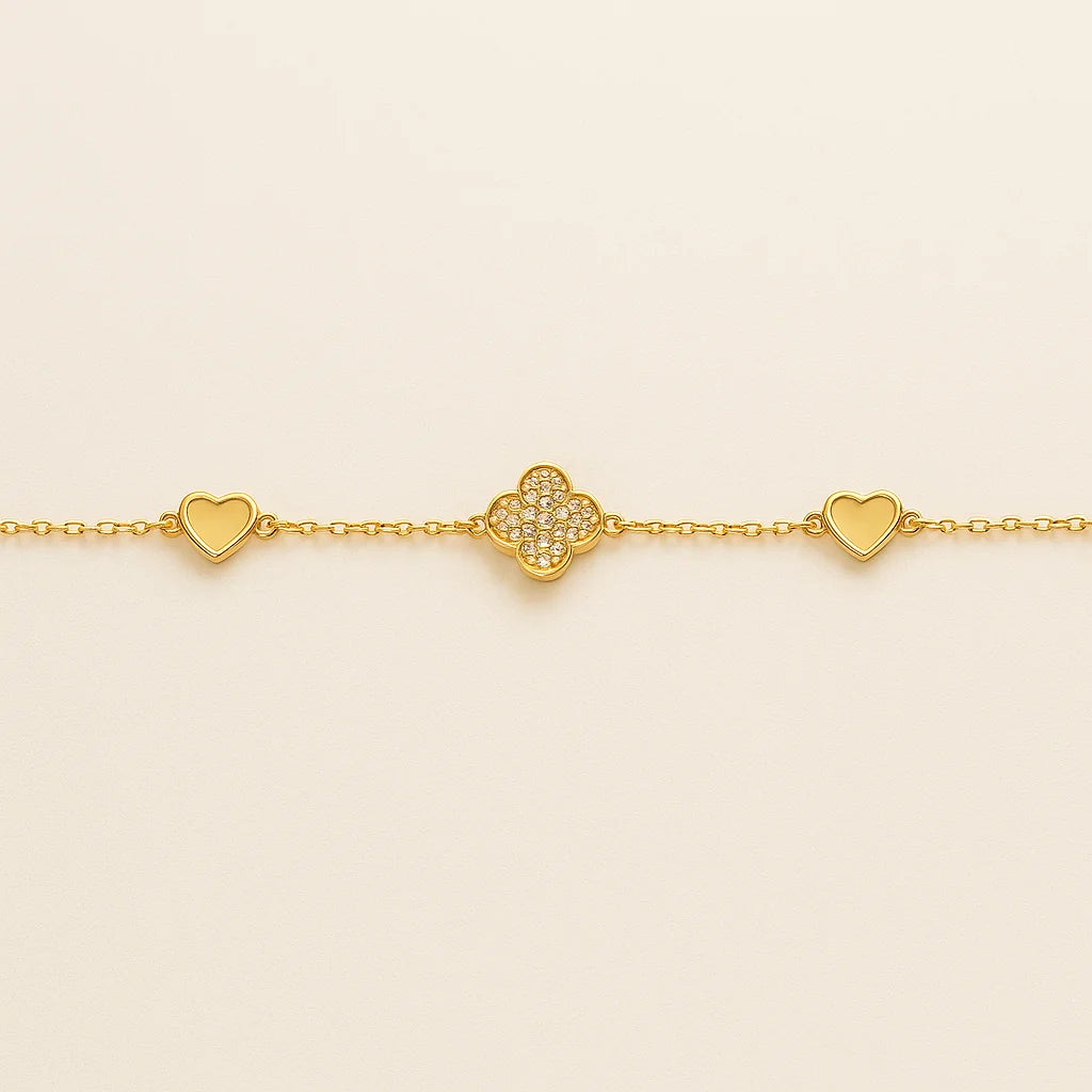 A beautiful gold-plated sterling silver bracelet featuring a central pavé clover charm flanked by two heart charms.