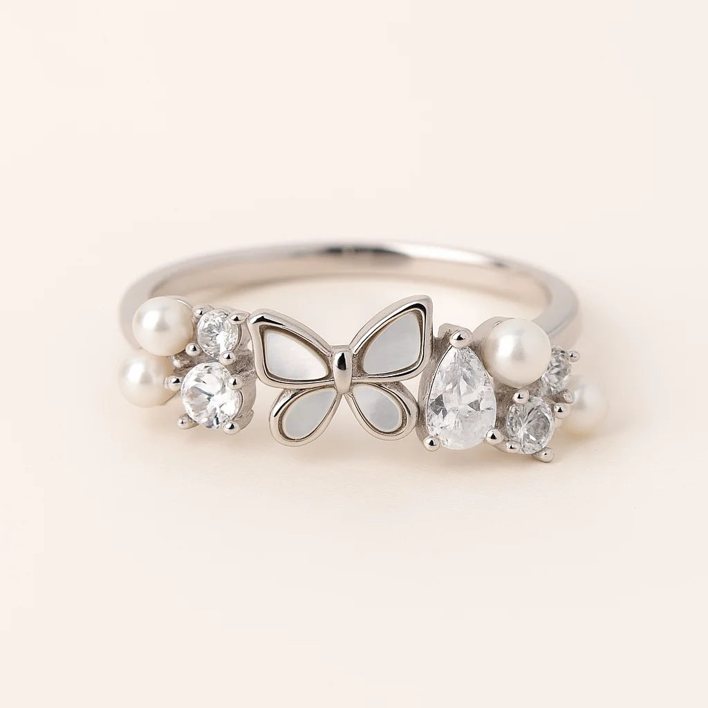 A 925 sterling silver ring with a mother-of-pearl butterfly and clusters of cubic zirconia stones and pearls.