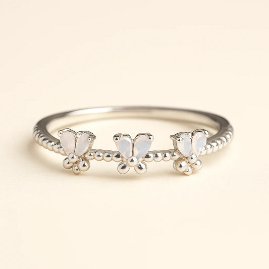 A detailed 925 sterling silver ring featuring three butterflies with opalescent wings and a beaded band.