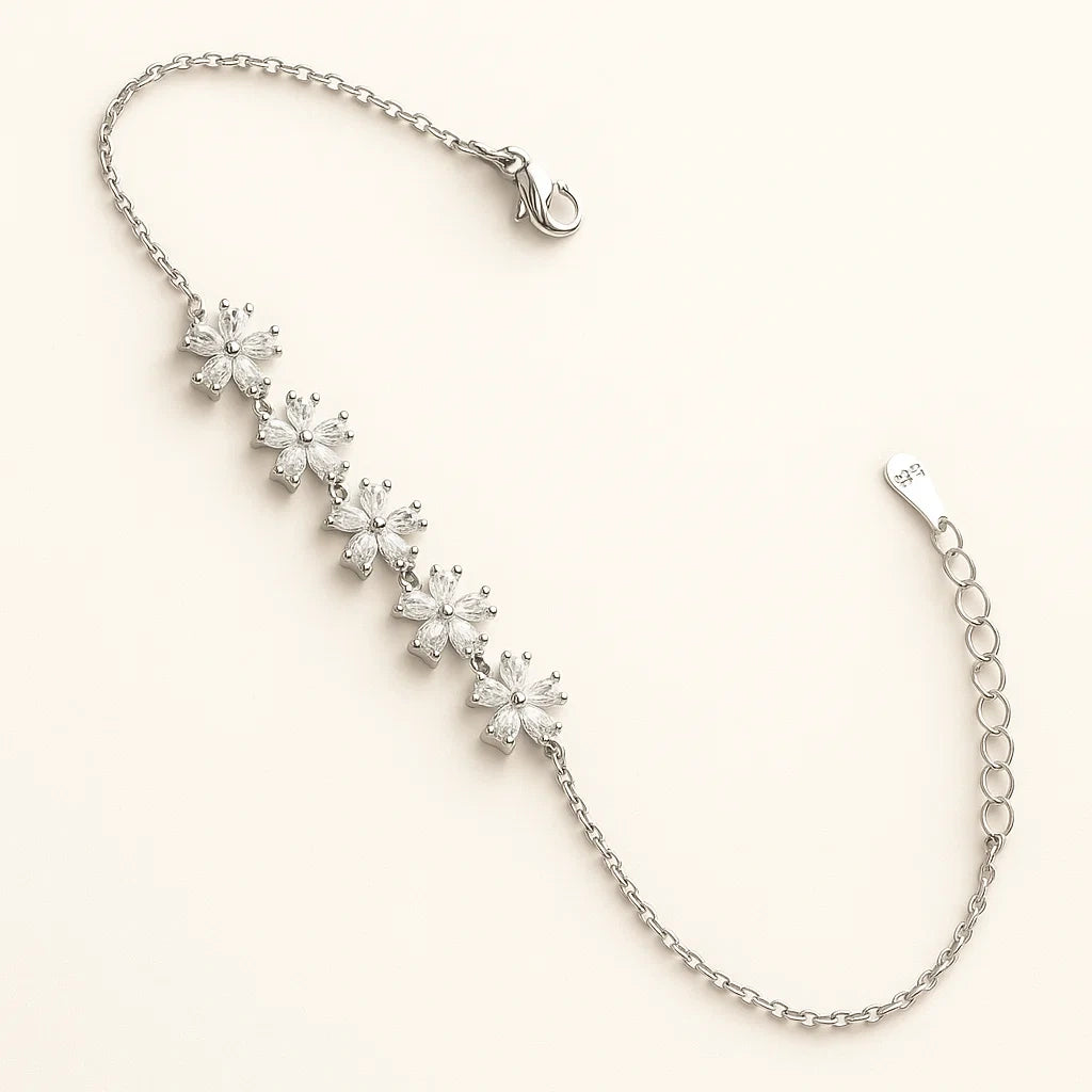 Silver bracelet with floral diamond charms on a light beige background