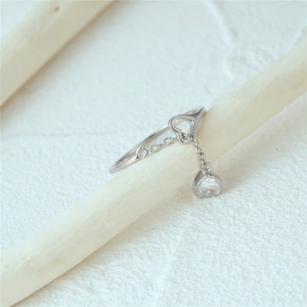 925 silver adjustable ring with two heart charms—one CZ-paved—connected by a fine dangling chain